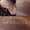 BOUDICCA frost finish eyeshadow shown loose and swatched on the skin. Boudicca is a strong plummy/russet brown, with complex highlight effects of green/gold and blue/teal.