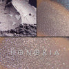 HONORIA eyeshadow loose and swatched on the skin. Honoria is a lilac with grey tones and beautiful multi-tonal copper/pink highlights.