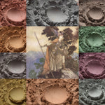 Collage showing loose piles of matte eyeshadow in nature toned shades surrounding an illustration done in matching watercolor paint and pencil of a viking shieldmaiden on a mountain.