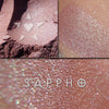 SAPPHO eyeshadow shown loose and swatched on the skin. Sappho is a beautiful pink with buff tones, and veils of blue, teal and turquoise overlays,