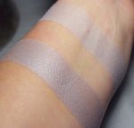 Selenia swatched on medium tone caucasian skin over primer and bare skin. A pale heathery lilac.