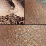 YAEL eyeshadow loose and swatched on the skin. Yael is a muted warm gold with soft gold to green multi-tonal effects. Glowing/Lustre finish.