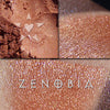 ZENOBIA eyeshadow loose and swatched on the skin. Zenobia is a rich coral with gold, copper and chartreuse highlights